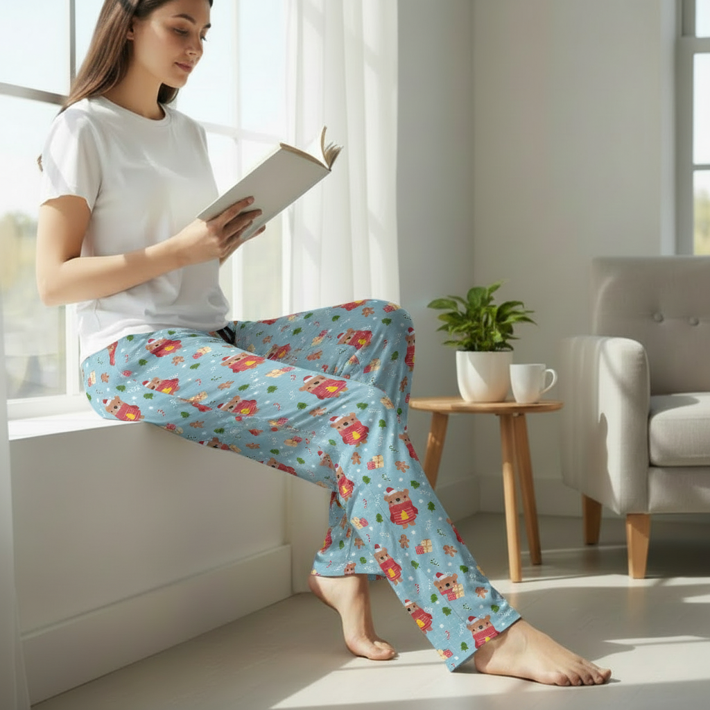 Woman wearing festive Christmas bear pajama pants reading by window - cozy holiday loungewear