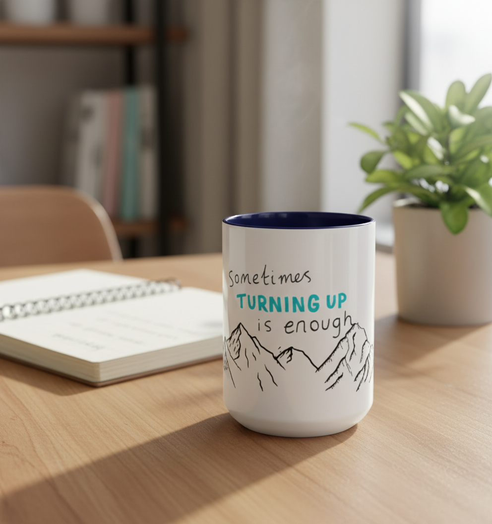 White ceramic mug with mountain quote on desk with plant - inspirational coffee cup home office decor