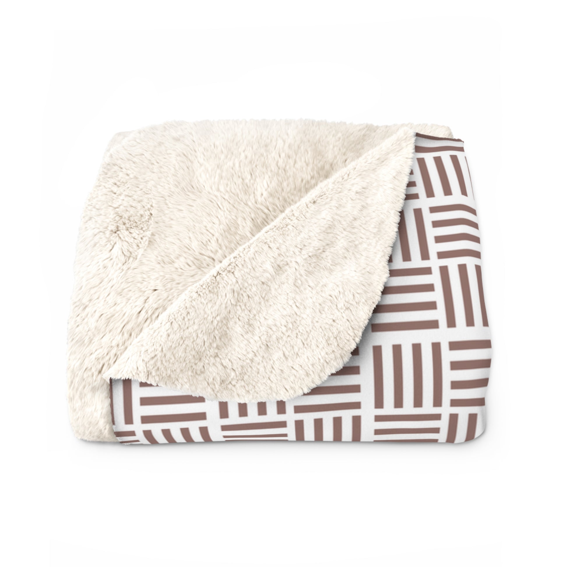 Folded blanket with white sherpa side and brown geometric patterned back on a white background