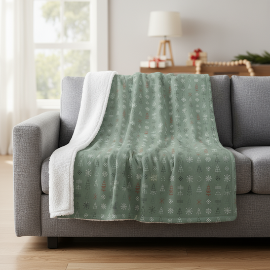 Green patterned blanket draped over a gray sofa in a living room.