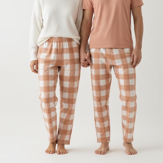 Couple wearing matching peach checkered pajama pants - back view showing coordinating lounge wear